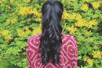 Rear view of woman standing by tree branches