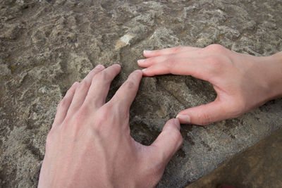 High angle view of man hand on rock