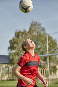 Girl practicing soccer on sunny day