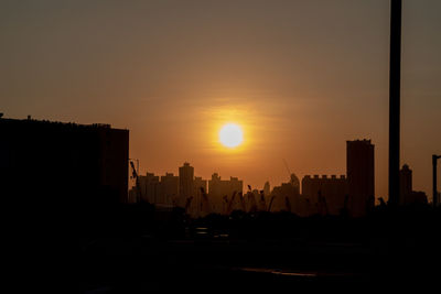 Silhouette buildings against sky during sunset