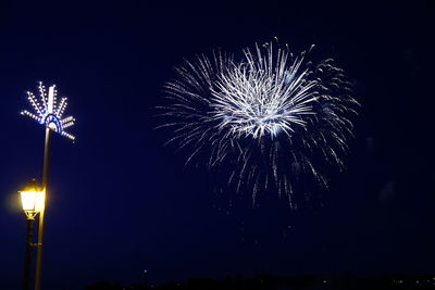 Low angle view of firework display at night