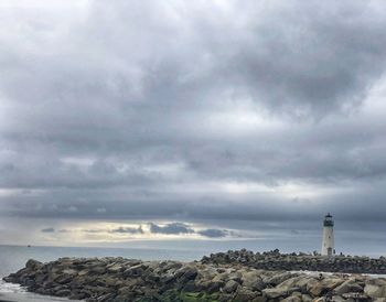 Lighthouse by sea against sky