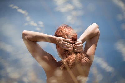 Rear view of woman braiding hair