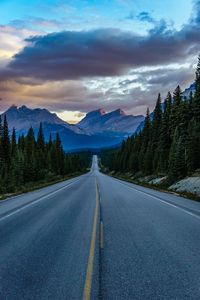 Road by mountains against sky