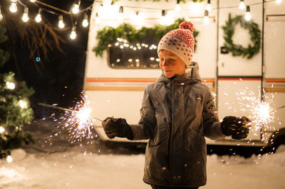 Portrait of young woman standing in city at night