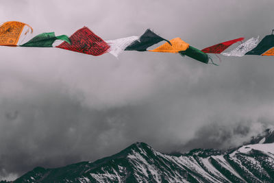 Low angle view of flags against sky during winter