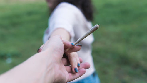 Close-up of couple holding marijuana joint