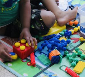 Midsection of boy playing with toy sitting on table