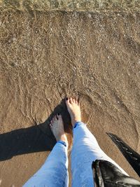 Low section of woman standing on beach