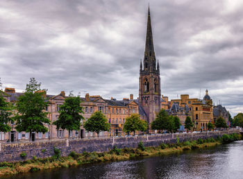 River in city against cloudy sky