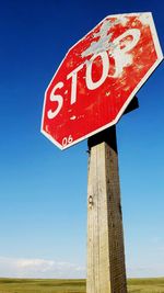 Stop sign shot at, weathered and neglected, still stands out in the wide open countryside 