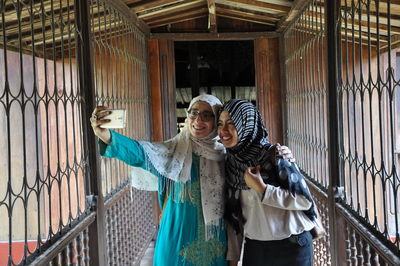 Friends taking selfie through mobile phone indoors