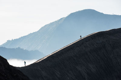 People on mountain against sky