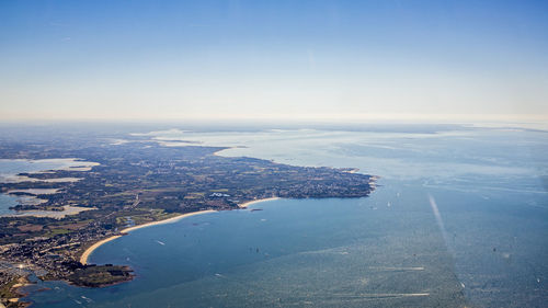 Aerial view of sea and cityscape against sky