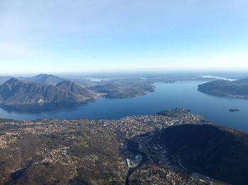 Aerial view of city by sea against sky