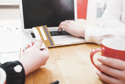 Midsection of man using laptop on table