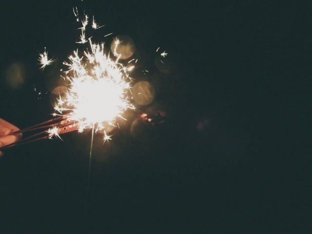 night, glowing, fire - natural phenomenon, illuminated, burning, person, sparks, flame, dark, part of, copy space, unrecognizable person, holding, arts culture and entertainment, sparkler, motion, cropped