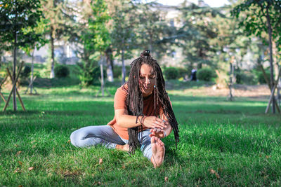 Beautiful young woman is doing yoga outside in a park. concept of healthy lifestyle.