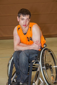 Portrait of man sitting against wall