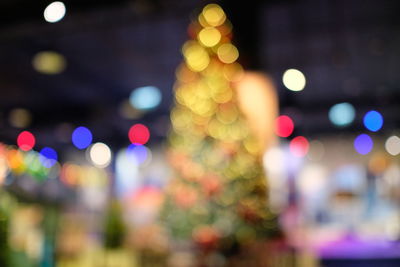 Defocused image of illuminated christmas tree at night