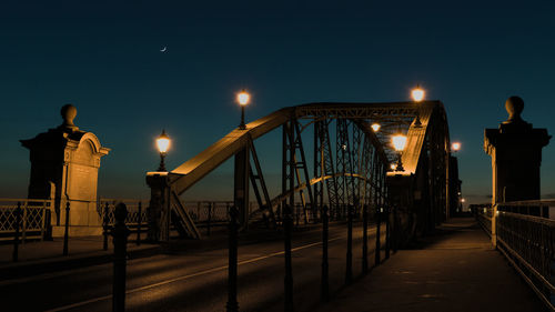 Illuminated bridge against sky at night