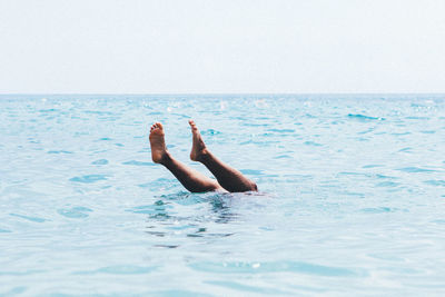 Low section of man swimming in sea