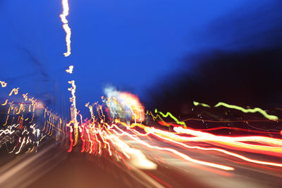 Light trails on road against sky at night