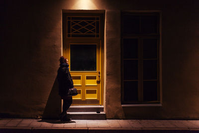 Man standing outside house at night