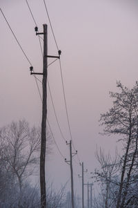 Low angle view of electricity pylon against clear sky