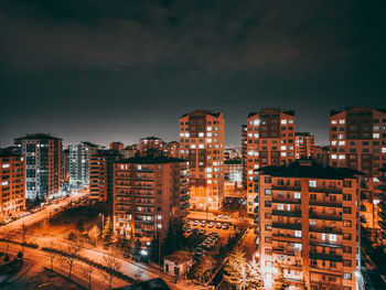 High angle view of illuminated buildings against sky at night