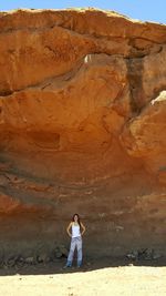 Woman standing on desert against sky