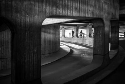 People walking in tunnel seen through window