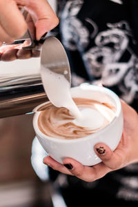 Close-up of hand holding coffee cup