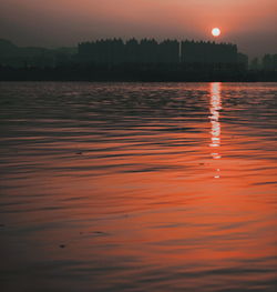 Scenic view of lake against sky at sunset