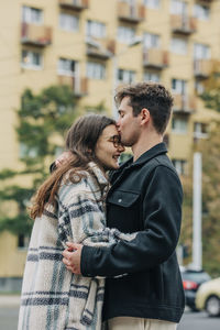 Young man kissing girlfriend on forehead