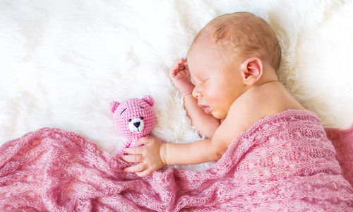 High angle view of cute baby boy sleeping on bed