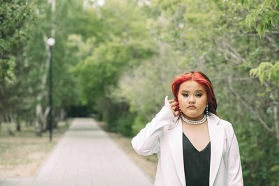 Bold confidence, young woman with eye-catching red hair reflects her unique style, personality