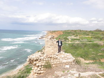 People standing by sea against sky