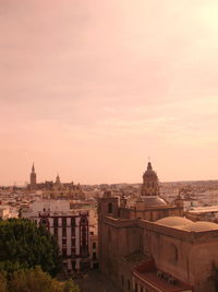 Buildings in city against sky during sunset