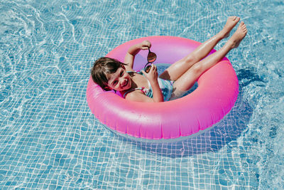 Portrait of smiling girl with inflatable ring in swimming pool