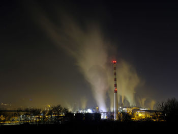 Smoke emitting from factory against sky at night