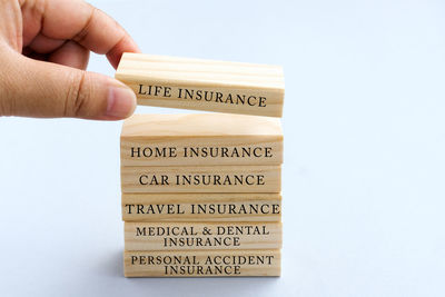 Close-up of hand holding text over white background