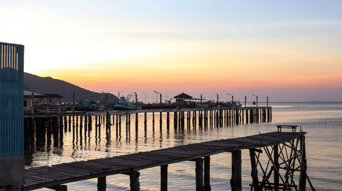 Pier over sea against sky during sunset