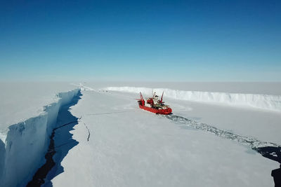 Scenic view of frozen lake against clear blue sky