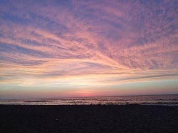 Scenic view of sea against dramatic sky during sunset