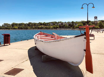 Boat on pier by beach against sky