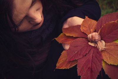 Close-up of person with autumn leaves