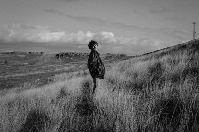 Man standing on field against sky