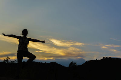 Silhouette man standing against sky during sunset