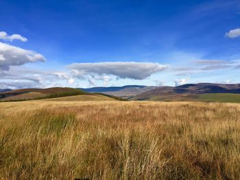 View of grassy landscape against cloudy sky